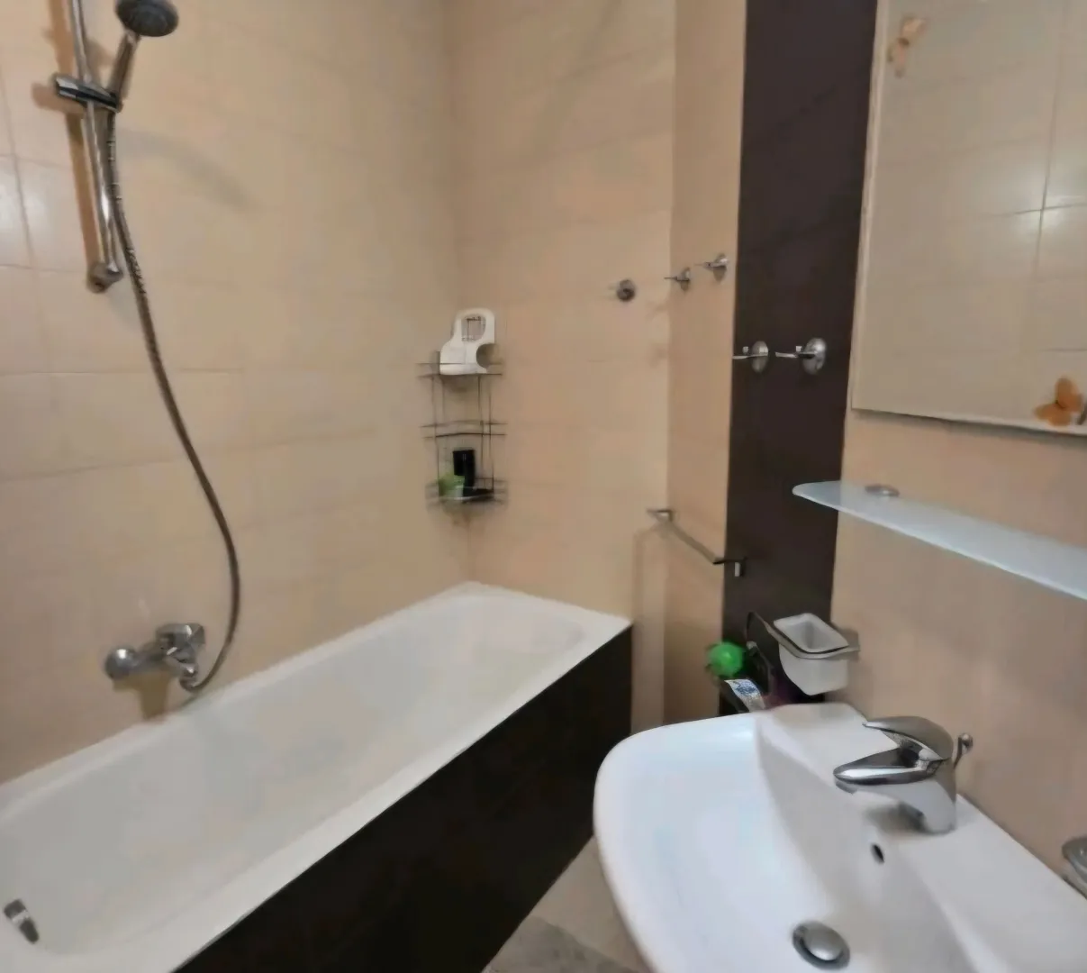 Smaller bathroom with a bathtub, washbasin, and mirror.