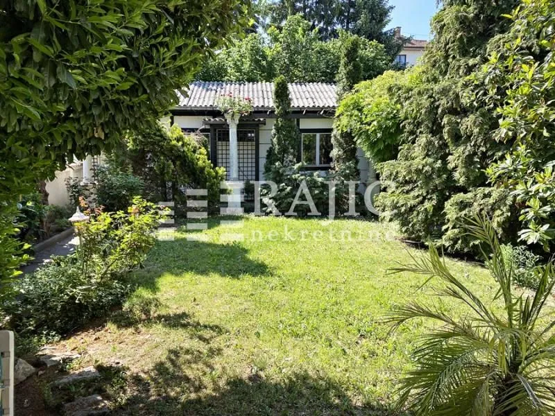 View of the yard and house surrounded by greenery.