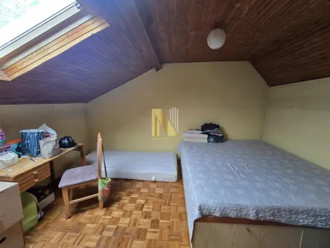 Potkrovlje opremljeno krevetima, stolom i drvenim plafonom. - image 14