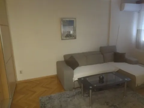 Dnevna soba sa ugaonom garniturom, stočićem i parketom na podu. - image 3