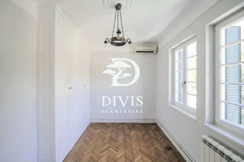 Empty bedroom with a built-in wardrobe and parquet flooring.
