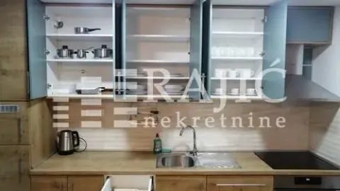 Modern kitchen with open upper cabinets and a built-in sink. - image 5