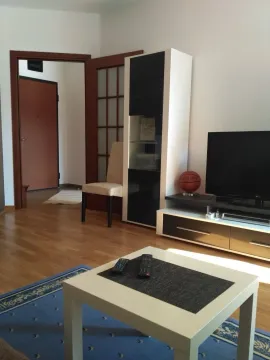 Living room with television unit, coffee table, and chair. - image 2