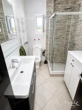 Modernly equipped bathroom with a shower cabin, washbasin, and toilet. - image 8