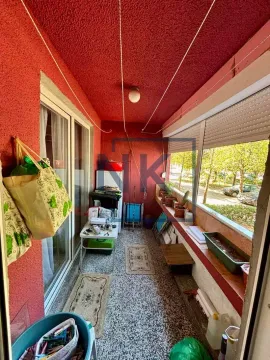 Zastakljeni balkon sa crvenim zidovima i prostorom za odlaganje stvari. - image 10