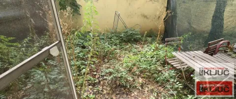 Zaraslo dvorište sa drvenim stolom i stolicama pored objekta. - image 11