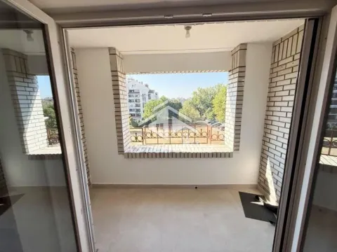 Nenamešten balkon sa pogledom na okolne zgrade i zelenilo. - image 16