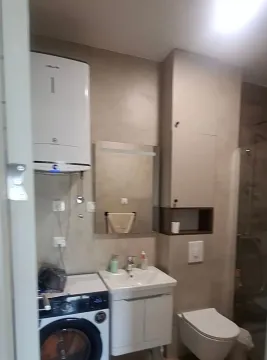 Moderno opremljeno kupatilo sa umivaonikom, veš mašinom i tuš kabinom. - image 7