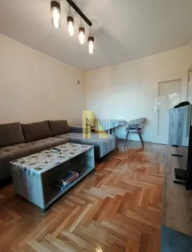 Dnevna soba sa garniturom, stočićem i parketom na podu. - image 6