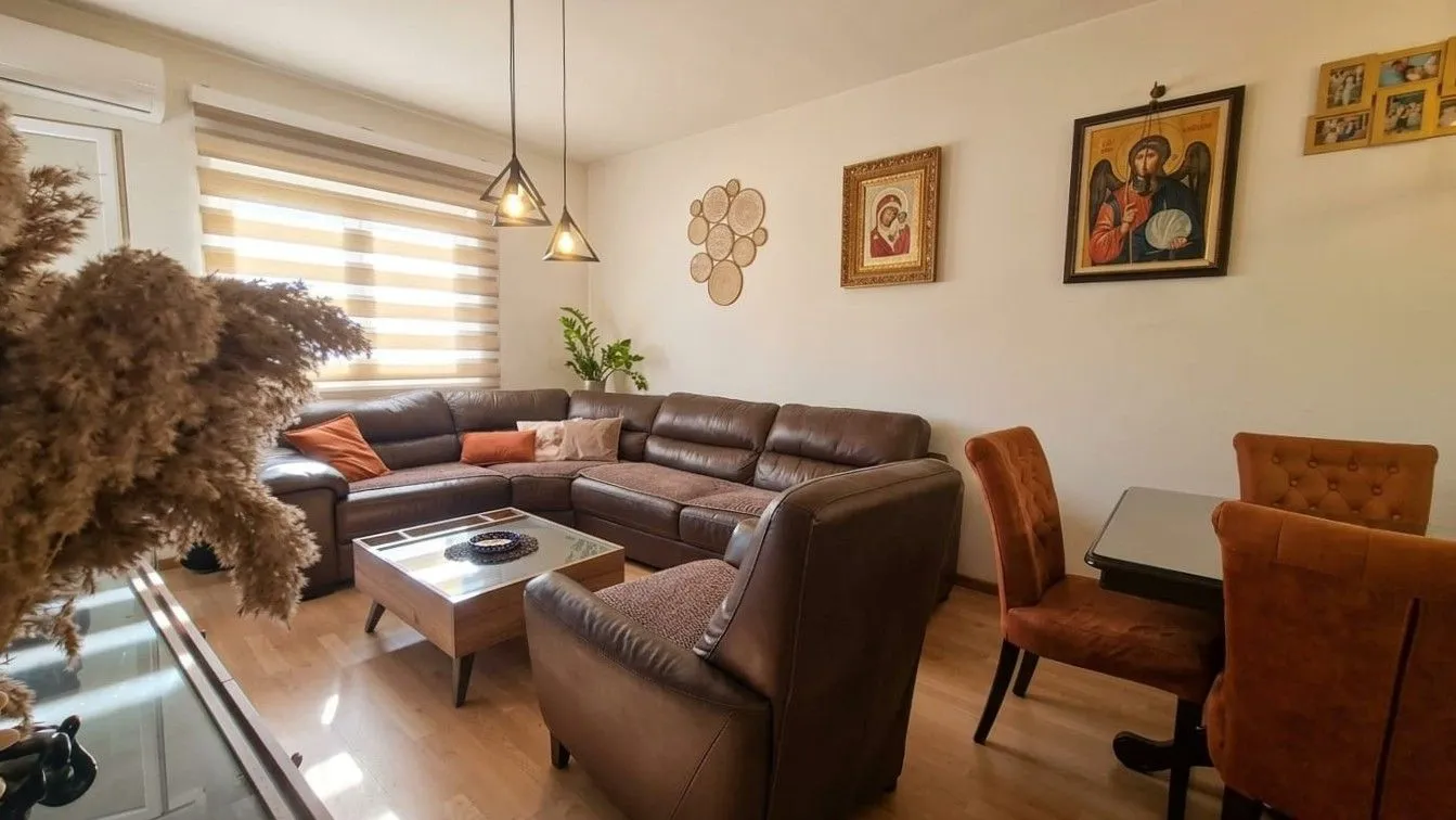 Living room with a sectional sofa, armchair, and dining table.