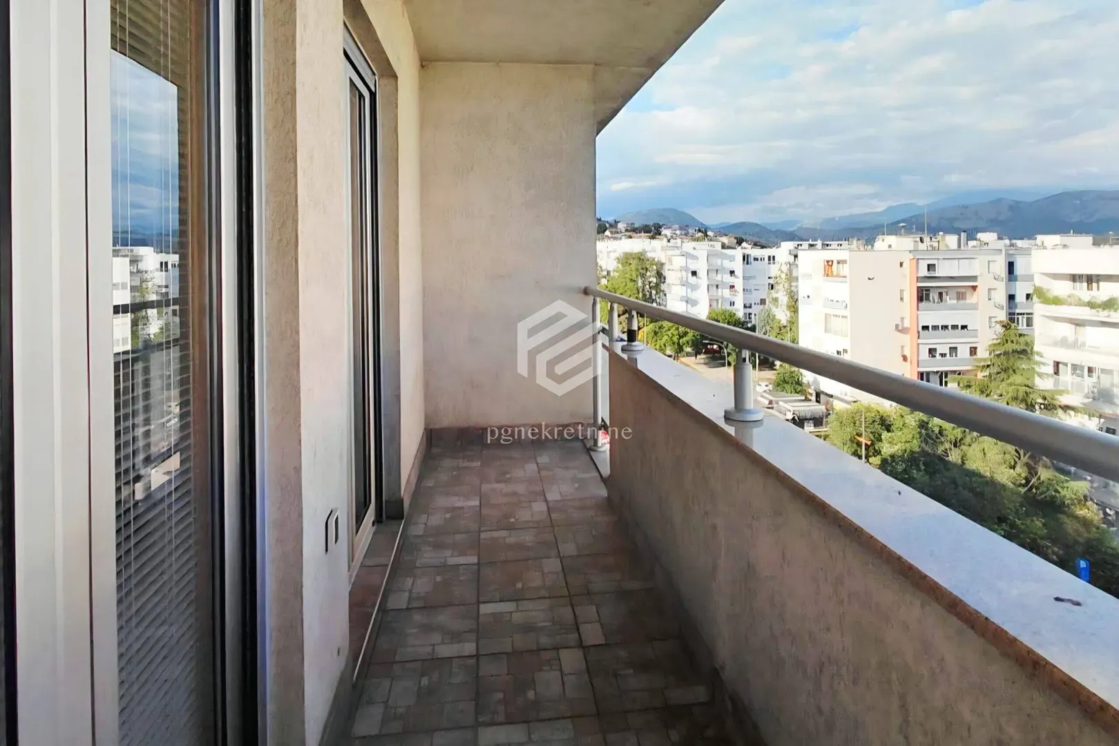Natkriveni balkon sa pločicama i pogledom na grad.