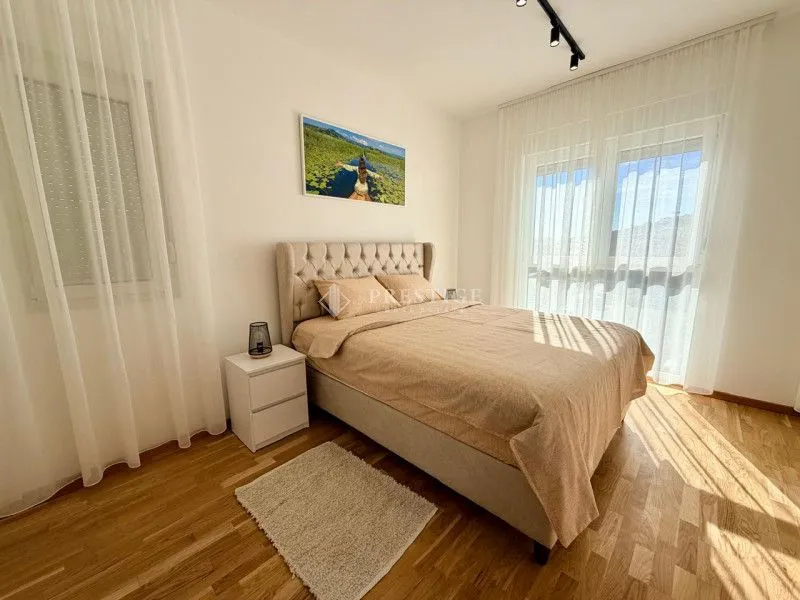 Bright and tidy bedroom with a double bed and hardwood flooring.
