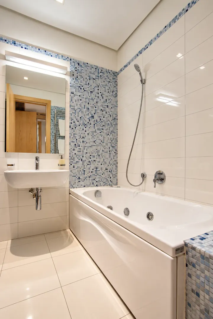 Modern bathroom equipped with a bathtub, washbasin, and mirror.