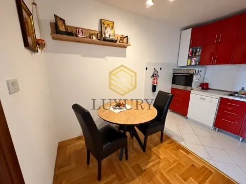 Manja kuhinja sa trpezarijskim stolom i crvenim elementima. - image 6