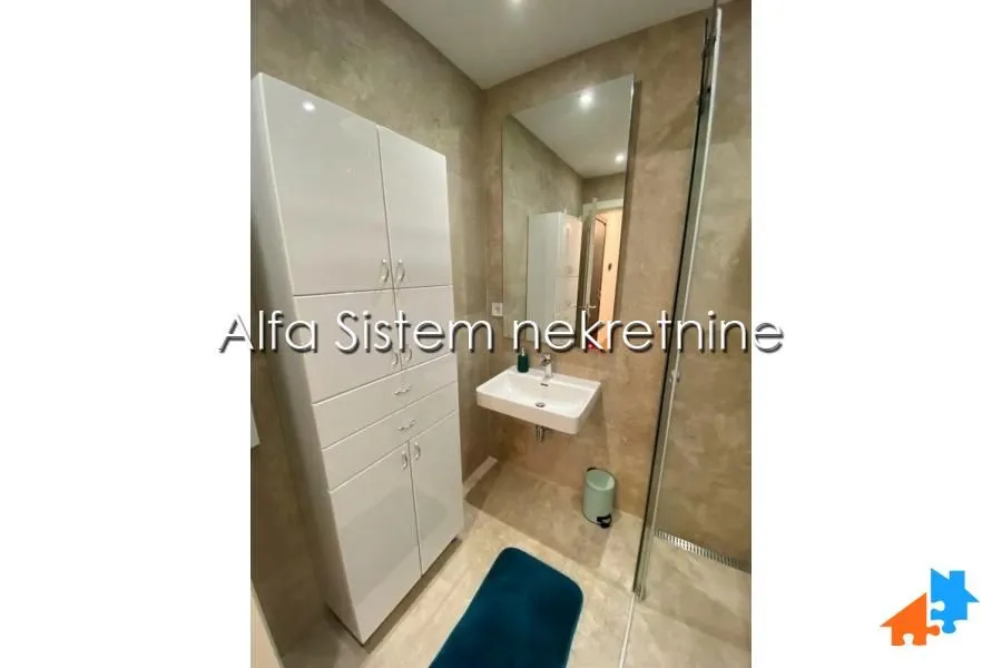 Modern bathroom with a sink, large mirror, and white cabinet.