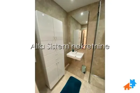 Modern bathroom with a sink, large mirror, and white cabinet. - image 10
