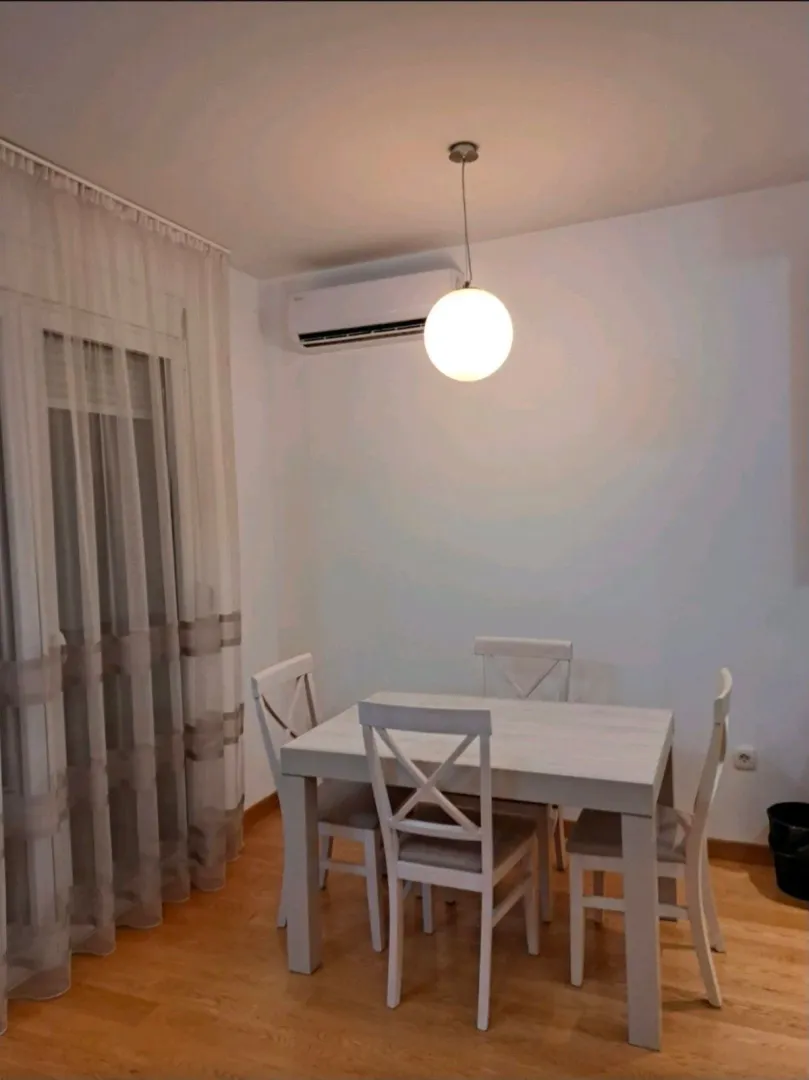 Trpezarija sa bijelim stolom i stolicama.