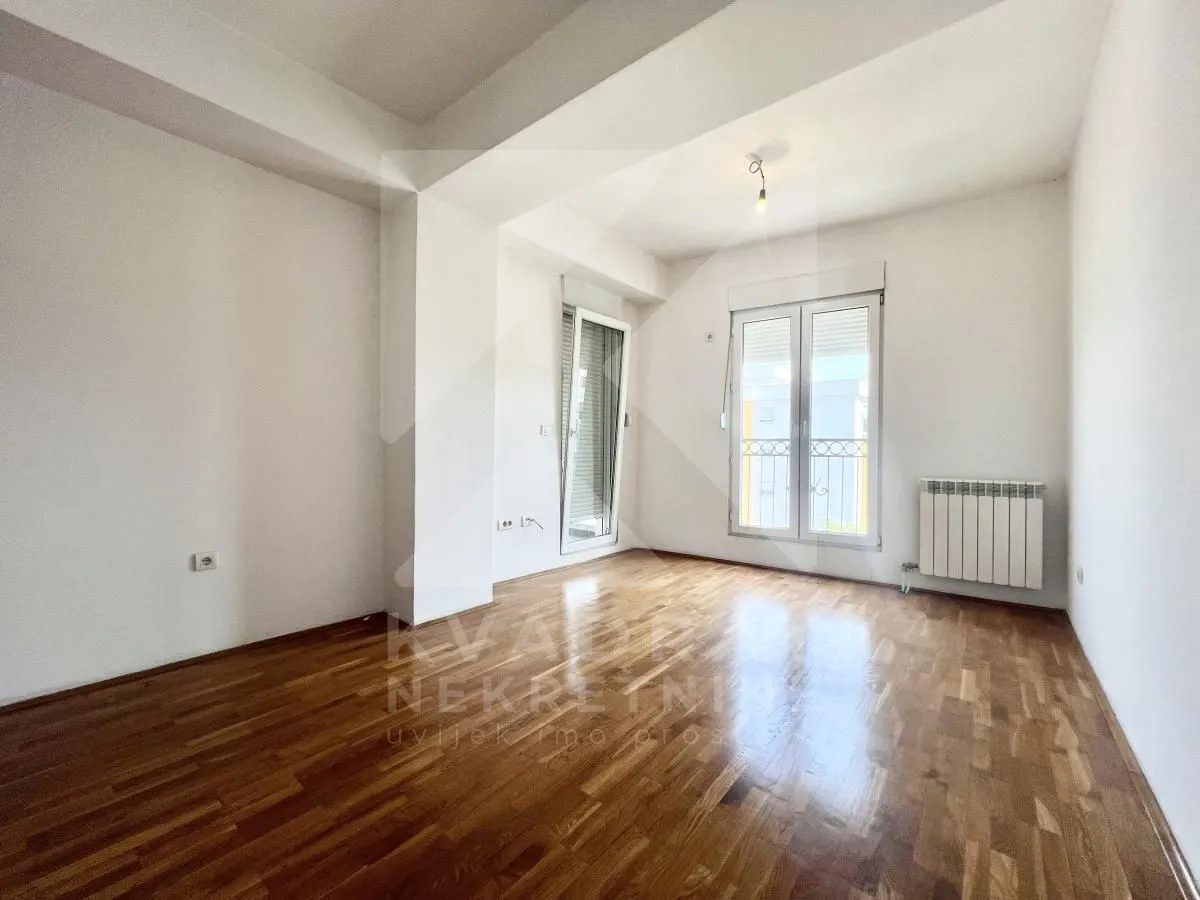 Empty room with parquet flooring and access to the terrace.