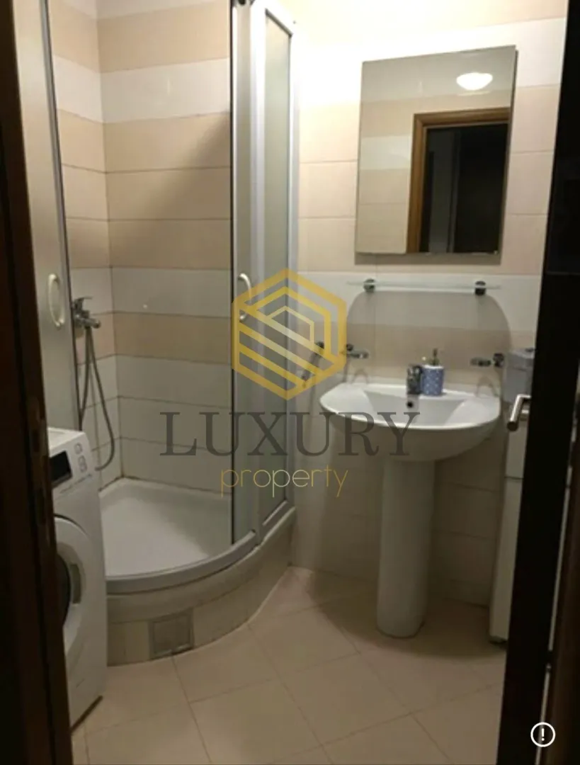 Small bathroom with a shower cabin, washbasin, and mirror.