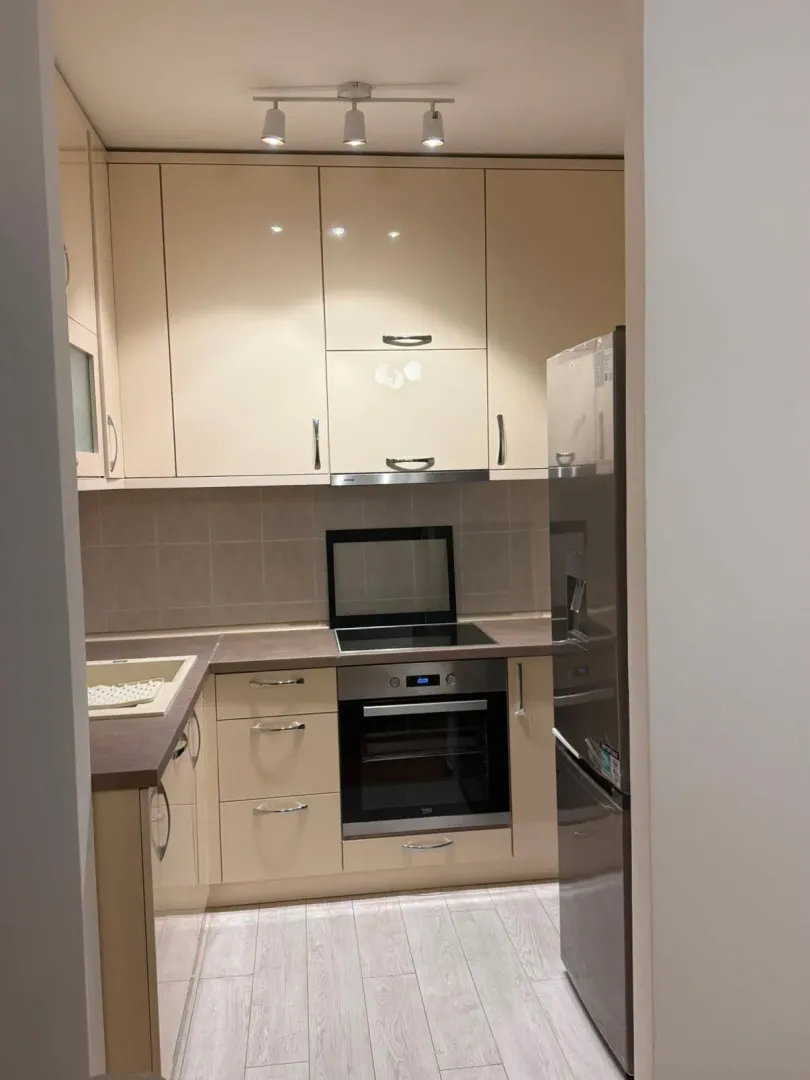 Modern kitchen with beige cabinets and built-in appliances.