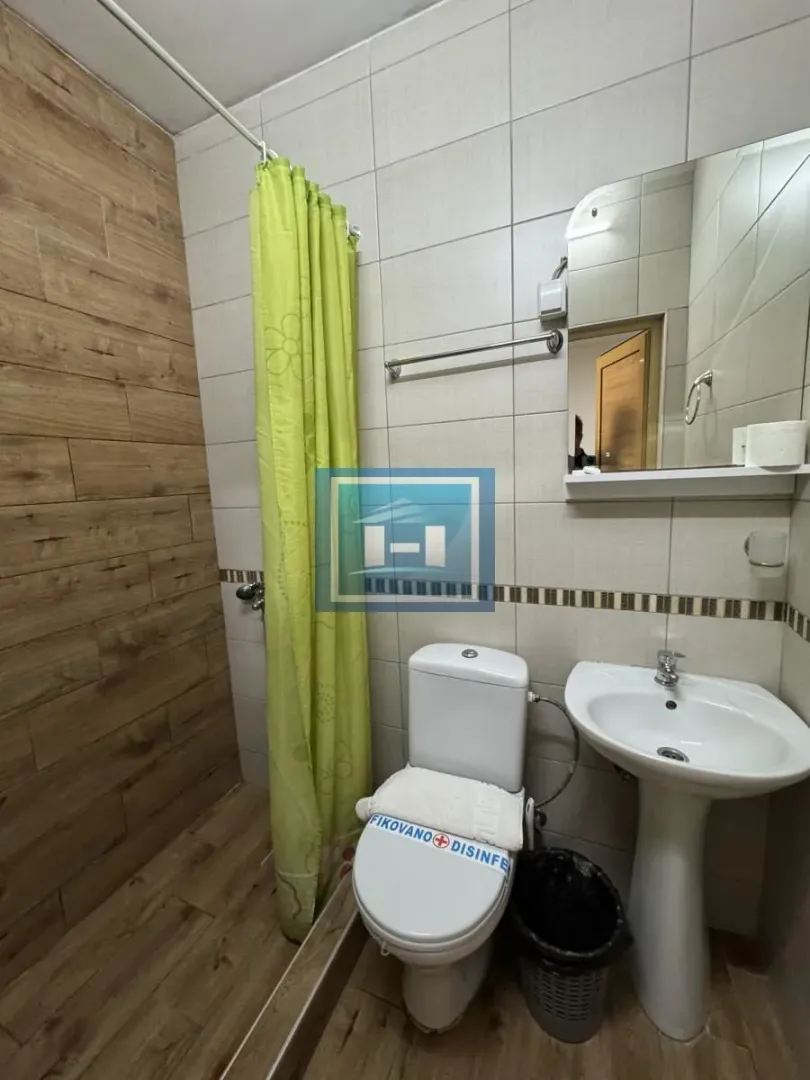 Smaller bathroom with a shower enclosure, washbasin, and toilet.