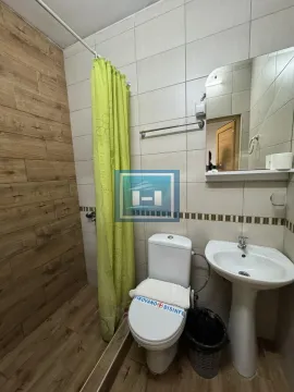 Smaller bathroom with a shower enclosure, washbasin, and toilet. - image 27