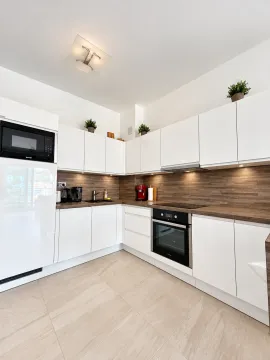 Modern white kitchen with wooden countertops. - image 4