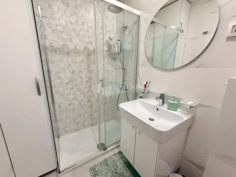 Modern bathroom with a shower cabin, washbasin, and mirror. - image 11