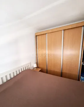 Bedroom with a double bed and a large wooden wardrobe. - image 11