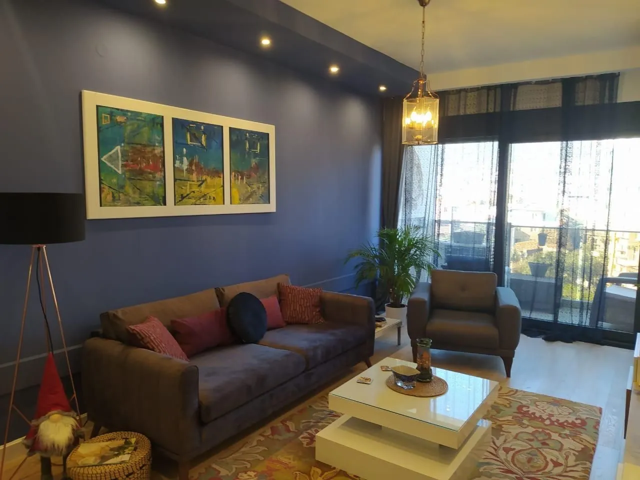 Modern and bright living room with a sofa and a blue wall.
