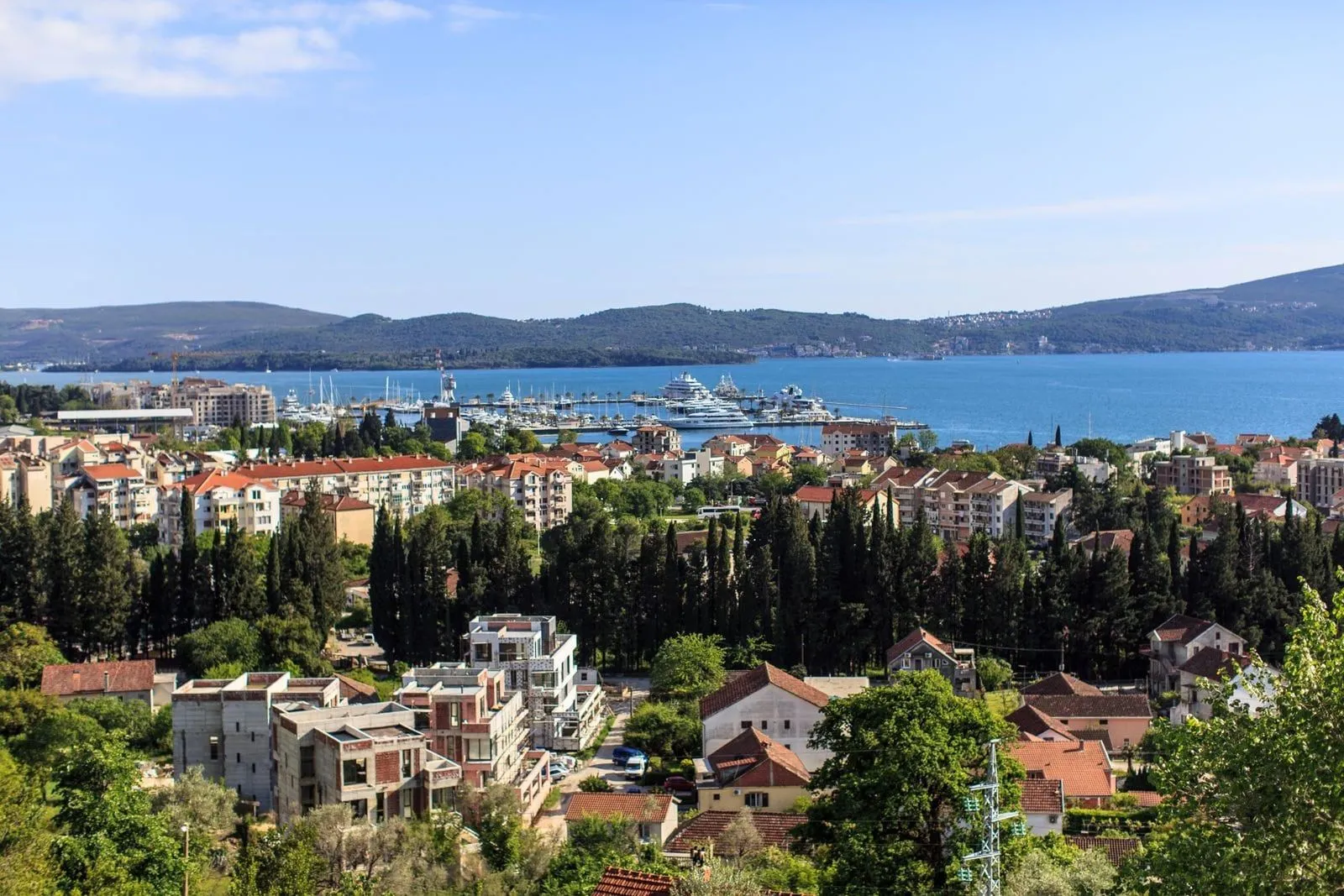 Panoramski pogled na grad i more sa marinom u daljini.