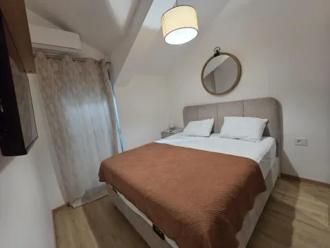 Bedroom with a double bed, wall mirror, and sloping ceiling. - image 21