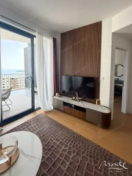 Dnevna soba sa TV-om, drvenim zidnim panelima i izlazom na terasu. - image 4