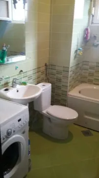 A simple bathroom with a bathtub, sink, and washing machine. - image 5