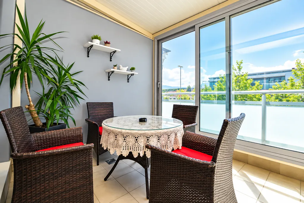 Enclosed terrace with seating furniture and a view of the surroundings.