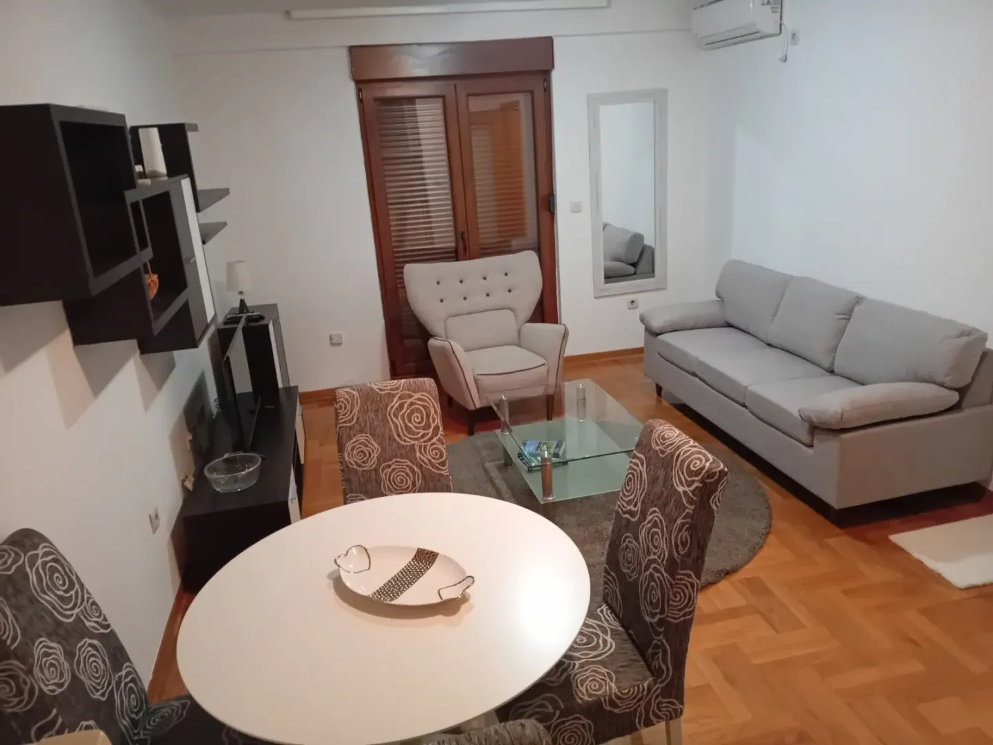 Dnevna soba sa trpezarijskim stolom, garniturom za sjedenje i TV komodom.