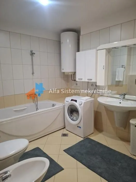 Bathroom equipped with a bathtub, washbasin, washing machine and sanitary fixtures.