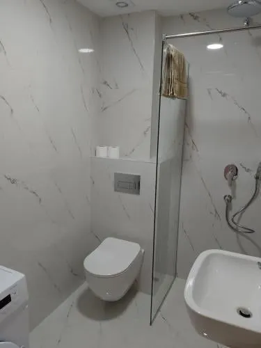 Modern bathroom with marble-patterned tiles and a walk-in shower.