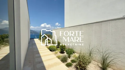 Exterior of the property with a paved walkway, landscaped greenery, and sea view. - image 5