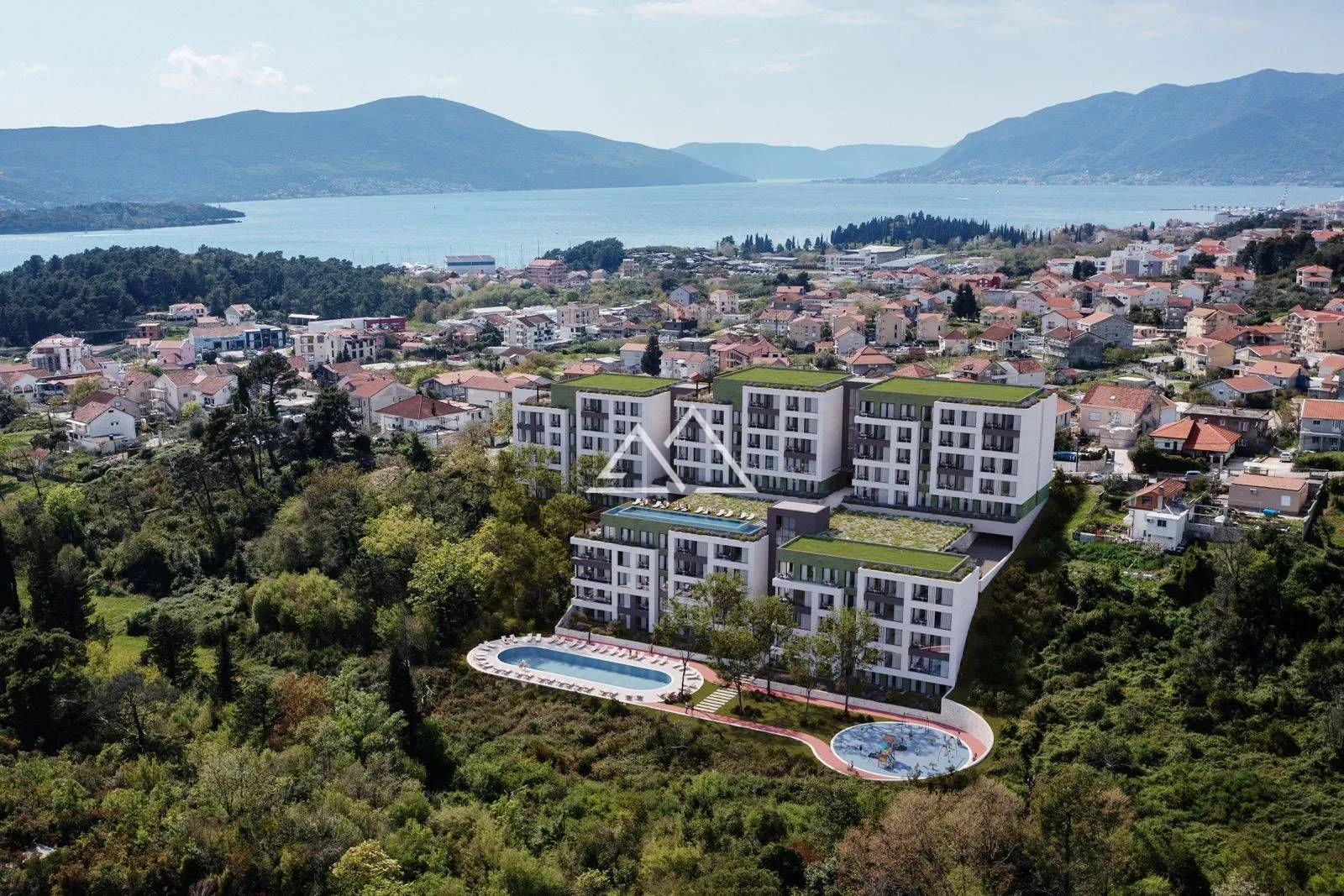Pogled iz vazduha na stambeni kompleks sa bazenom i pogledom na more.