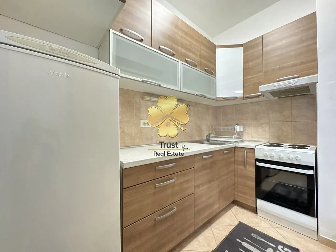 Small kitchen with wooden cabinets and white goods.