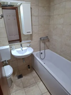 A bathroom with a bathtub, sink, and mirror cabinet. - image 13