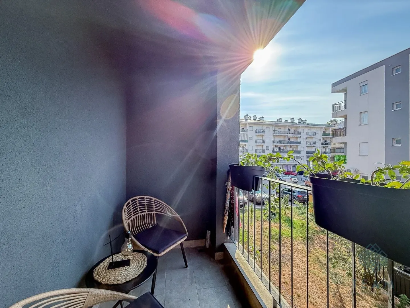 Furnished balcony with seating area and view of the neighborhood.