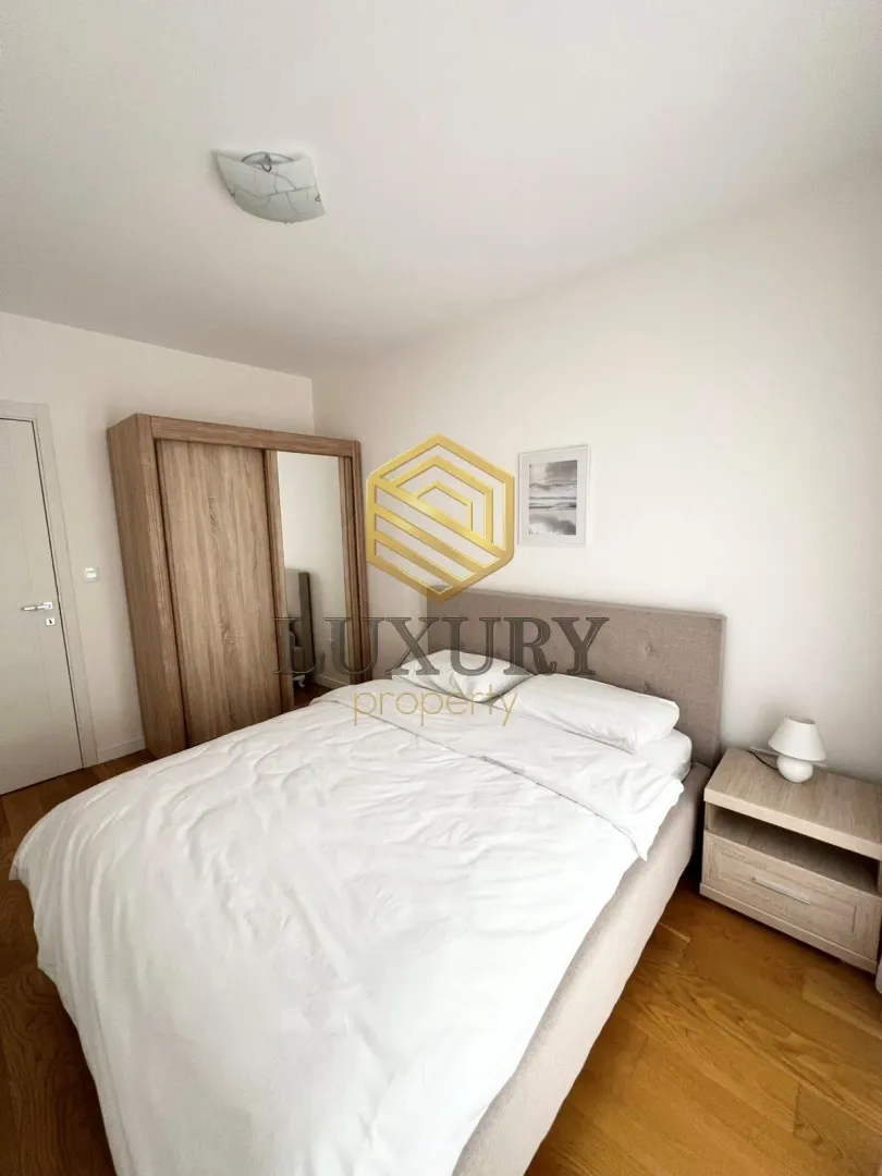 Furnished bedroom with a double bed, wardrobe, and a bedside table.