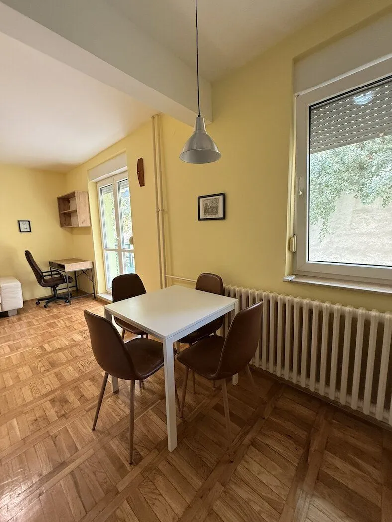 Living room with a dining table and a work corner.