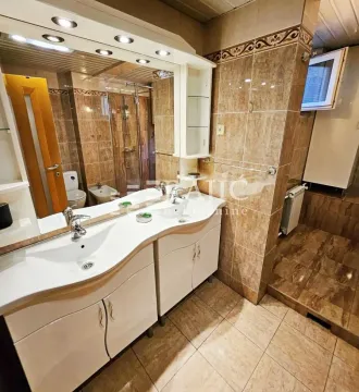 Tiled bathroom featuring a double vanity and a large mirror. - image 13
