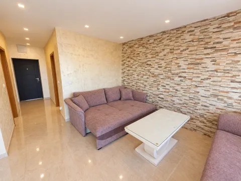 Living room with a sofa and a decorative stone wall. - image 4