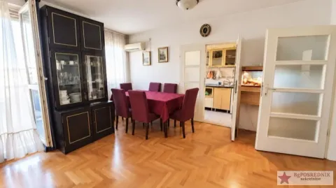 Dining room with a wooden table, chairs, and a dark cabinet. - image 3