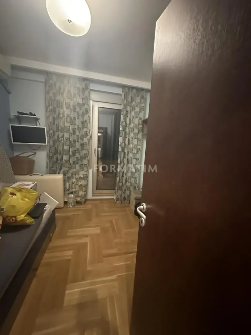 View of a small room with a bed and balcony doors.