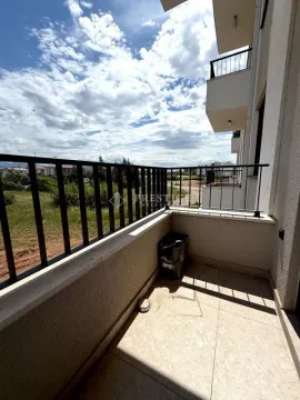 Smaller tiled balcony with a railing and a view of the surroundings. - image 12